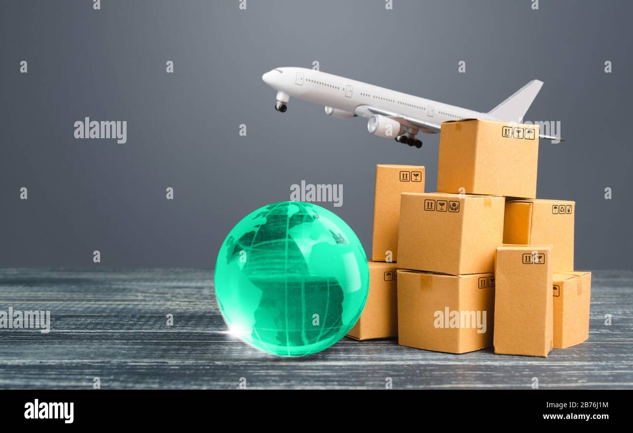 Hellgrüner Globus in der Nähe von Kartons und Frachtflugzeug. Internationale Lieferung von Waren und Produkten. Logistik, Infrastruktur-Hubs. Importieren, Exportieren Stockfoto
