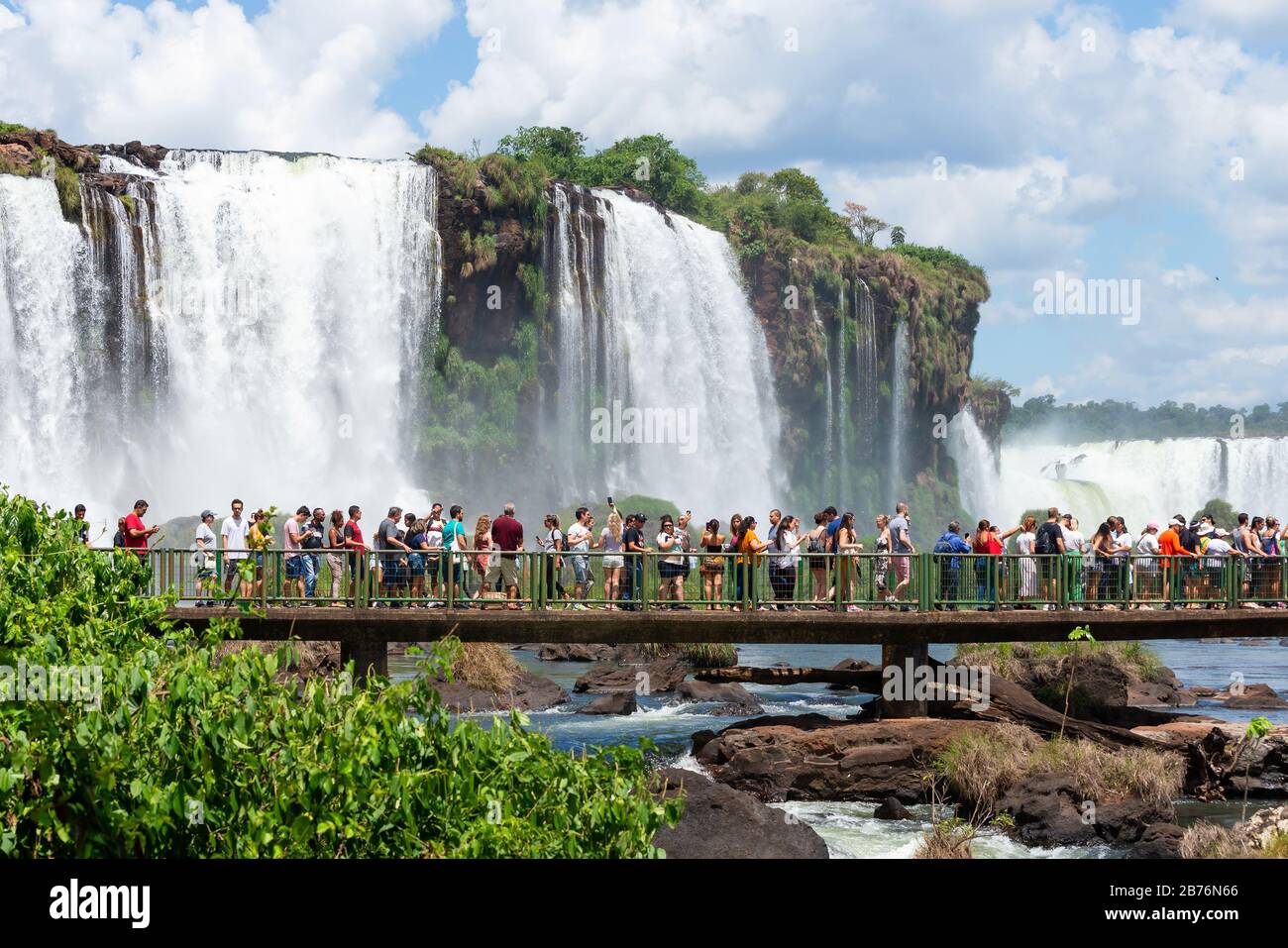 Touristenmassen auf einem Gehweg, der die Wasserfälle von Iguazu in Brasilien (Cataratas do Iguaçu) besucht. Schöne Naturlandschaft im Südamerika-Wald. Stockfoto