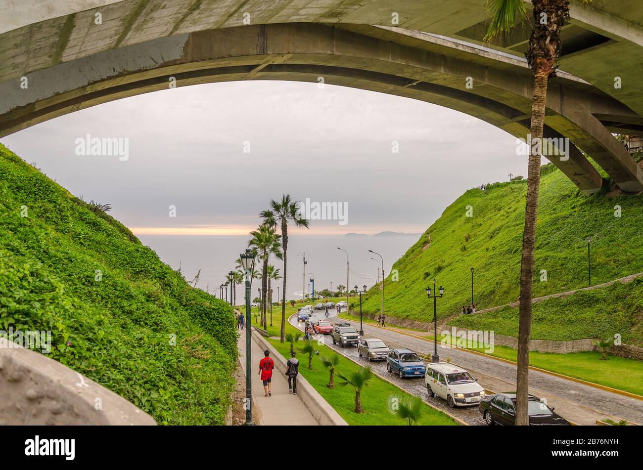 Blick auf den Pazifischen Ozean durch eine Brücke mit Gras und eine Straße in Lima, Peru Stockfoto
