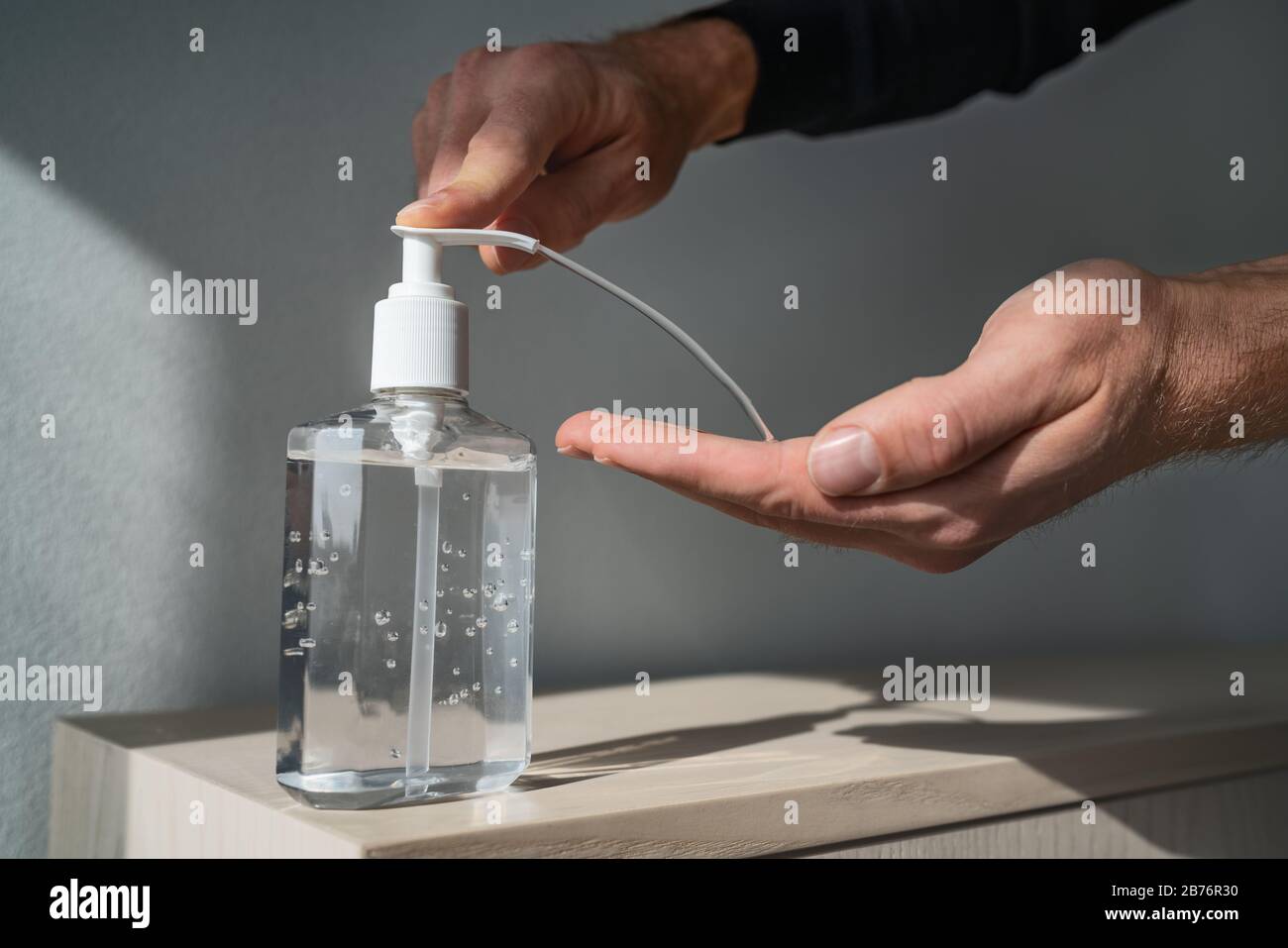 Händedesinfektionsalkohol Gel reiben saubere Hände Hygiene Prävention von Coronavirus Virus Ausbruch. Man verwendet eine Flasche antibakterieller Desinfektionsmittel. Stockfoto