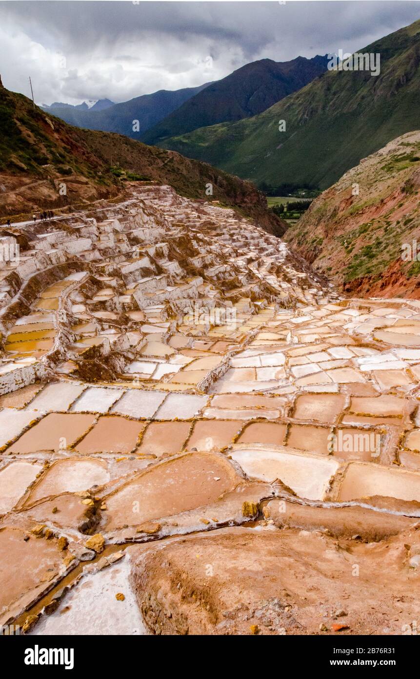 Salpeter in einem Tal an einem bewölkten Tag mit Bergen von Maras in Peru gebaut Stockfoto