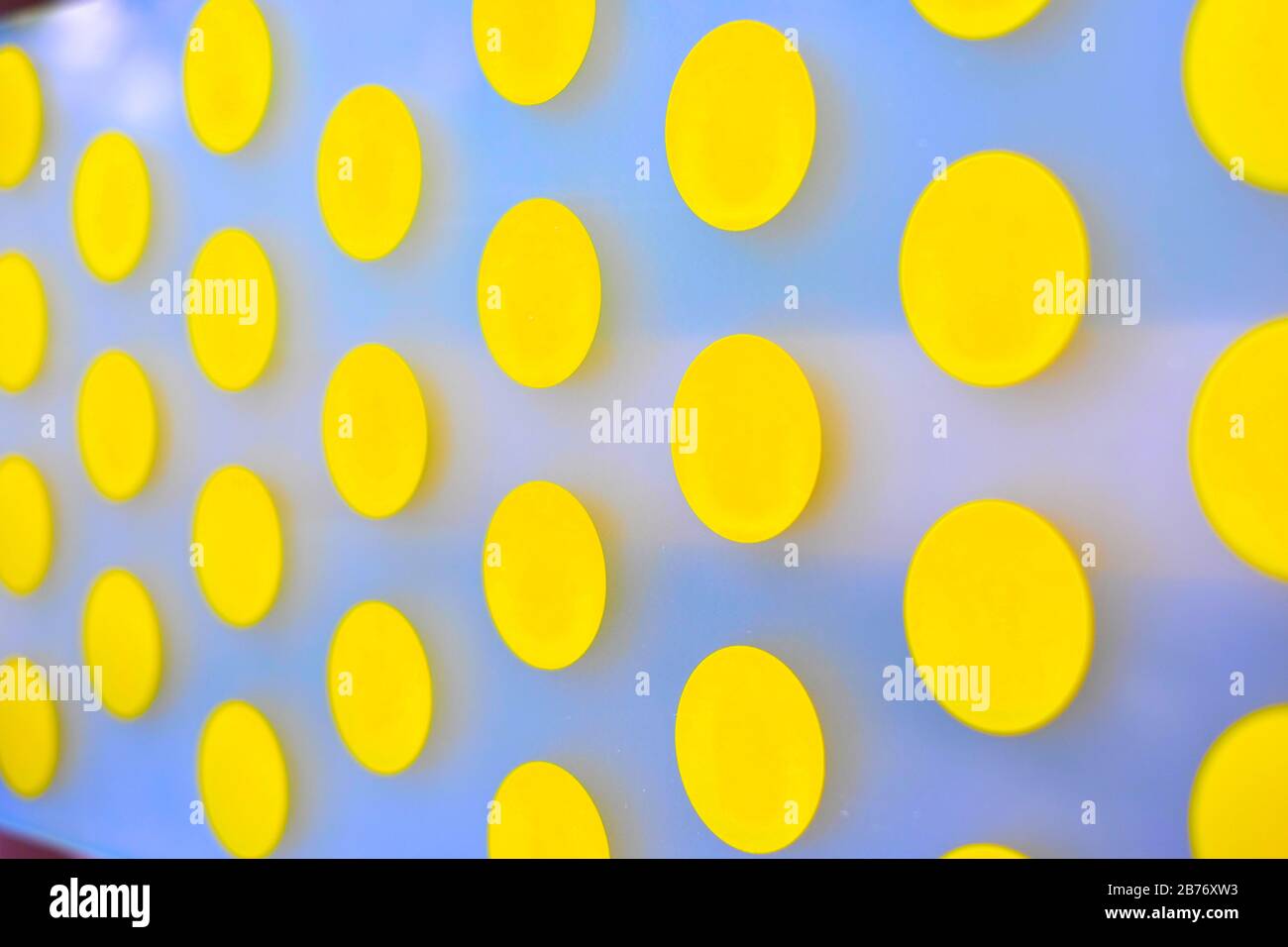 Leuchtend gelbes Punktmuster auf weißem Hintergrund, selektive Fokusperspektive. Stockfoto