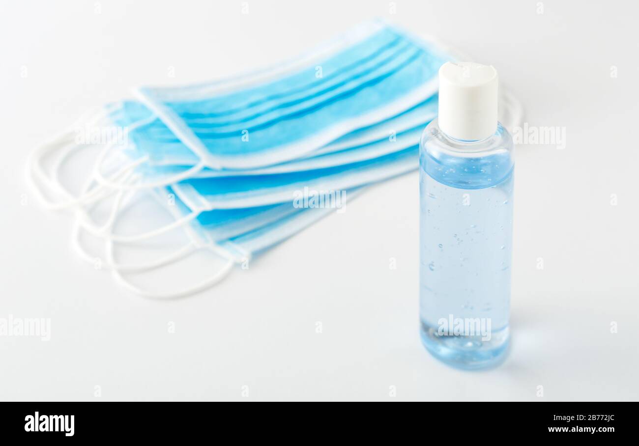 Vorbeugung gegen Coronavirus. Händedesinfektionsgel und medizinische chirurgische Schutzmasken auf weißem Tisch. Antibakterielle Seifendesinfektionsmittel mit Alkoholgel, Hände Stockfoto