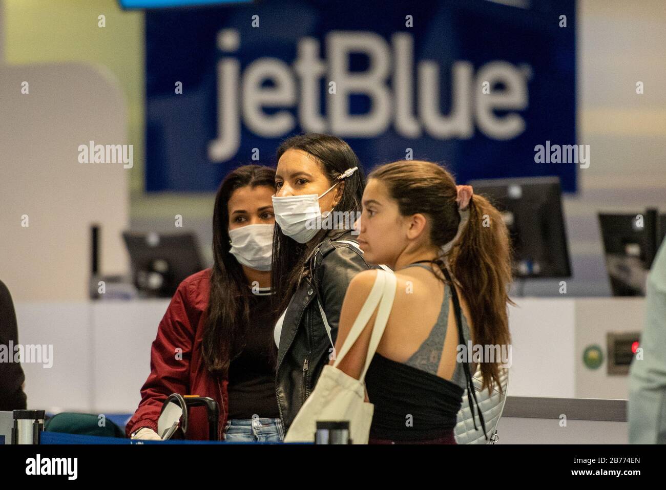 Fort Lauderdale, Florida, USA. März 2020. Reisende tragen Sicherheitsmasken am Fort Lauderdale International Airport, nachdem CDC die amerikaner davor warnt, in den USA zu reisen, in Angst, das Coronavirus zu verbreiten. Aufgrund des Reiseverbots von Präsident Trump aus 26 europäischen Ländern in die USA wird mit einem Rückgang der Reisewege gerechnet. Credit: Orit Ben-Ezzer/ZUMA Wire/Alamy Live News Stockfoto