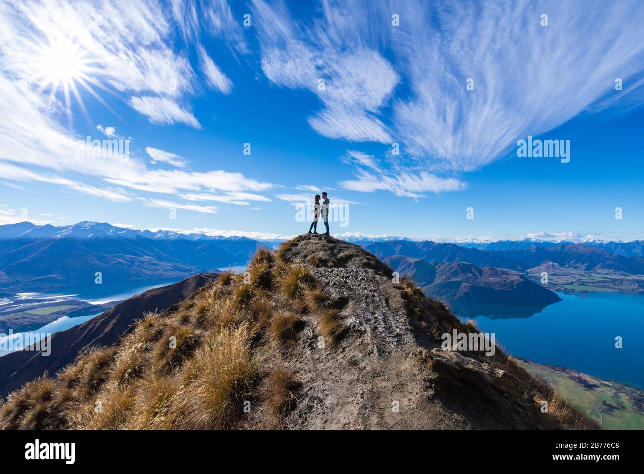 Junges asiatisches Paar, das die Hände am Roy's Peak Lake Wanaka Neuseeland küsst Stockfoto