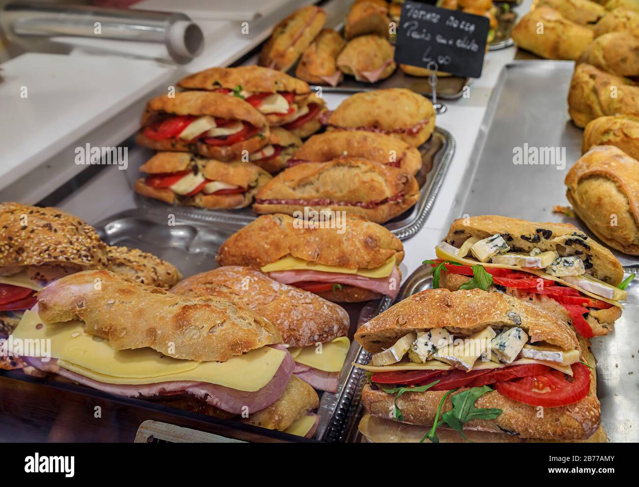 Auswahl an Sandwiches mit Schinken und Käse, Blaukäse, Tomaten und Arugula, Salami und anderen in einem lokalen Sandwich-Shop in Nizza, Frankreich Stockfoto