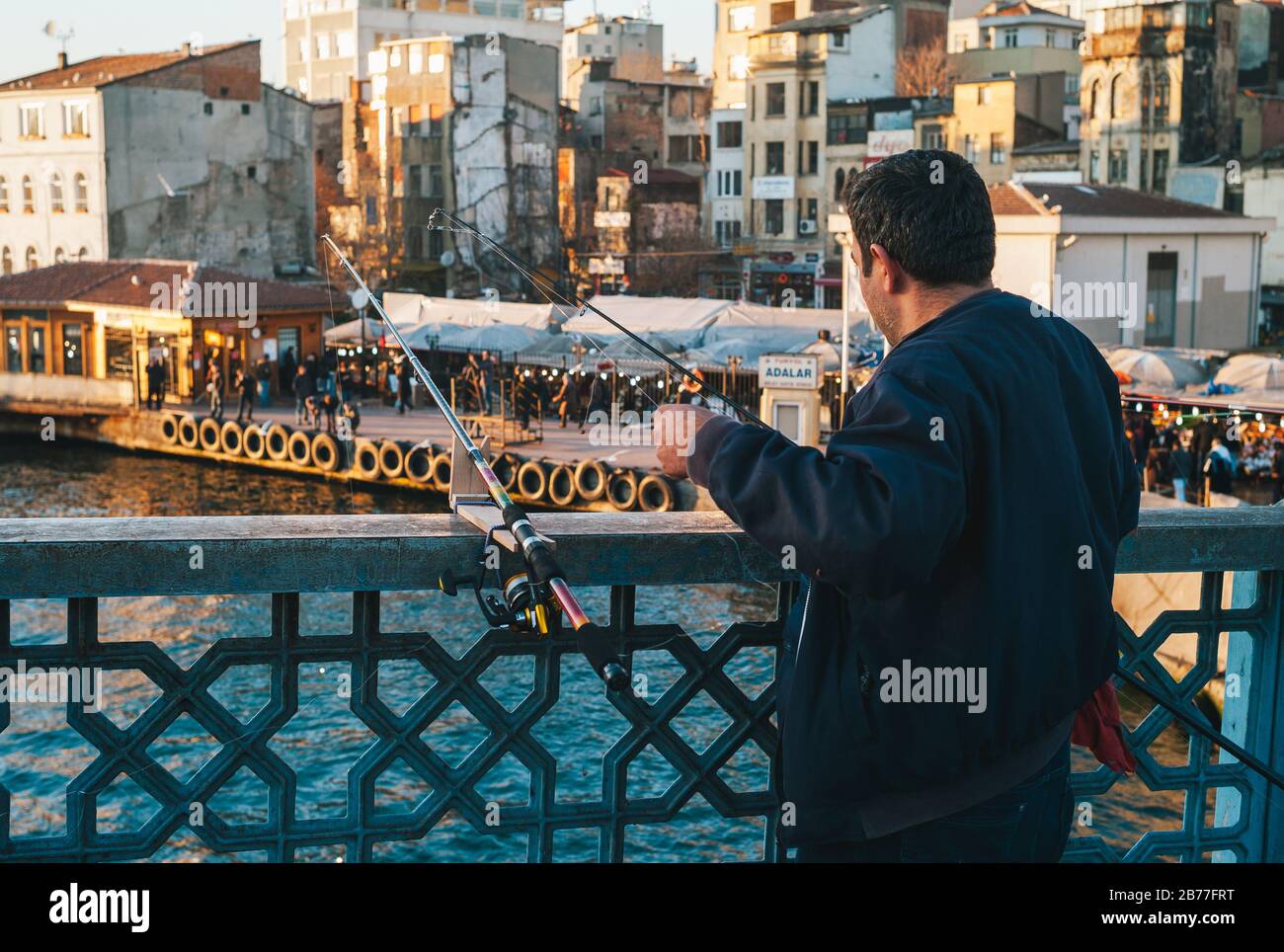 Istanbul, Türkei - 3. Januar 2012: Fischer-Angeln auf der Galata-Brücke mit seinen Angelruten Stockfoto