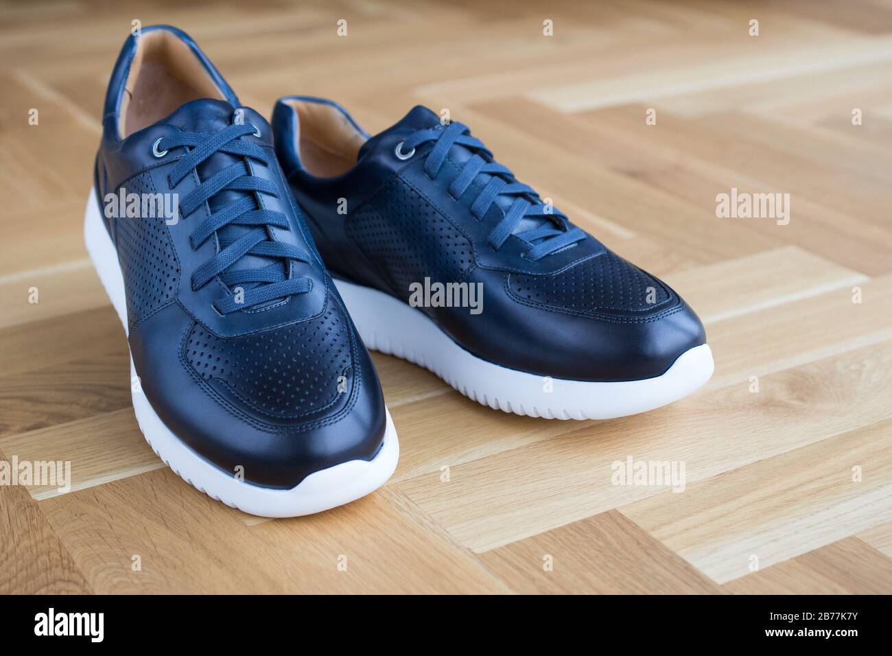 Trendige, moderne, luxuriöse Ledersneaker auf Holzflößerei Stockfoto