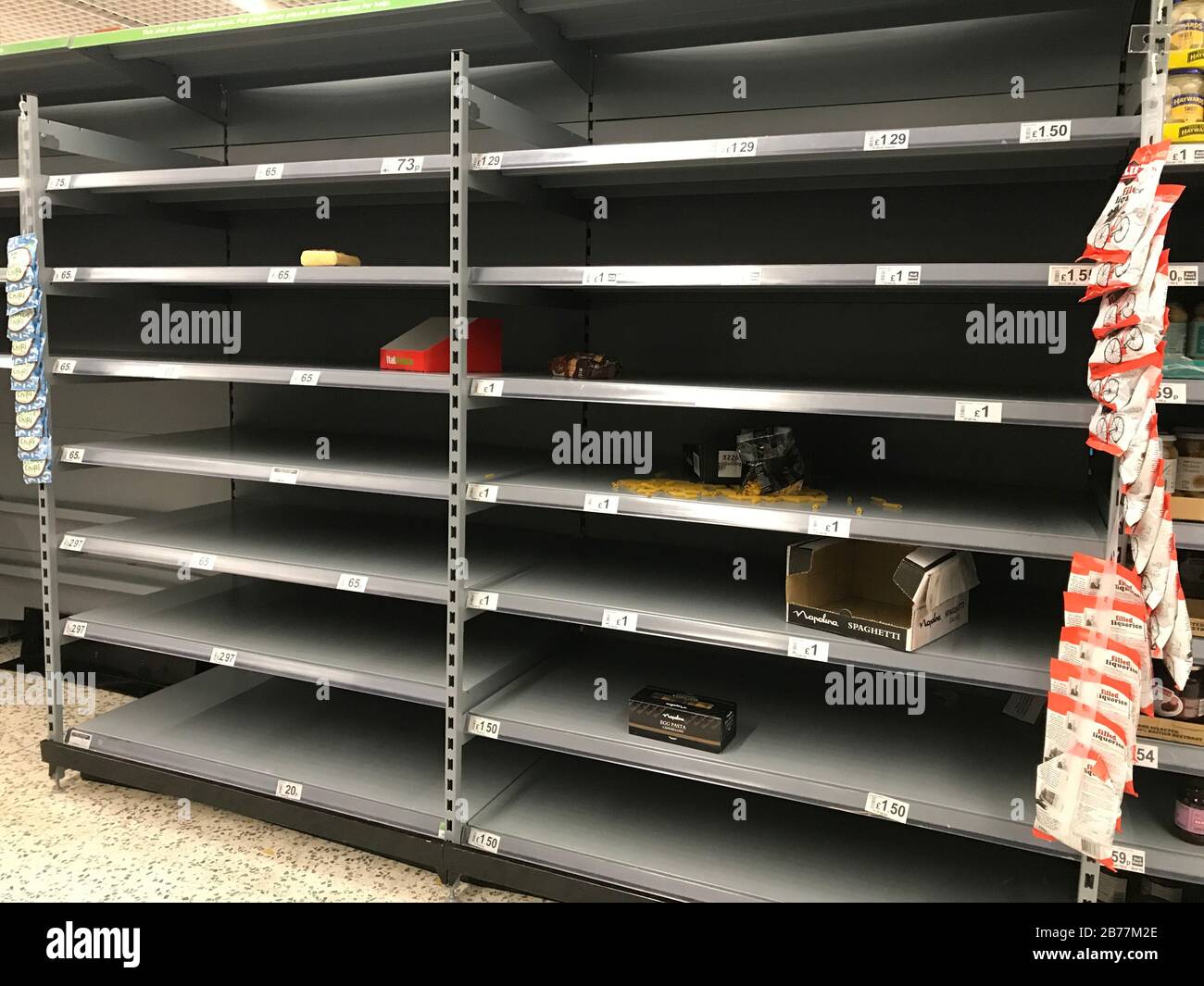 Leere Regale im Supermarkt in England. Käufe aufgrund von Coronavirus Panik in britischen Geschäften werden mit leeren Regalen gelassen. Stockfoto