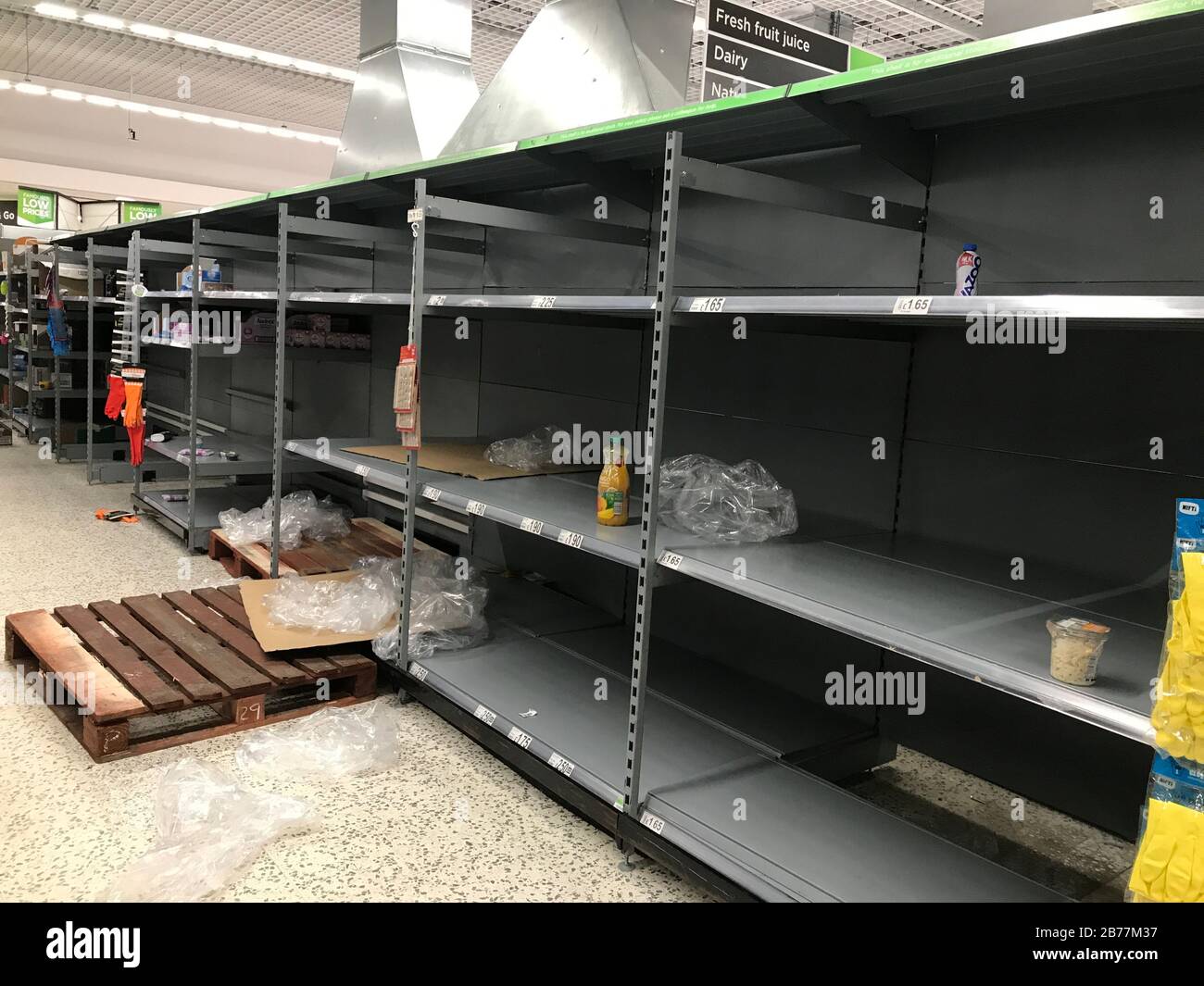 Leere Regale im Supermarkt in England. Käufe aufgrund von Coronavirus Panik in britischen Geschäften werden mit leeren Regalen gelassen. Stockfoto