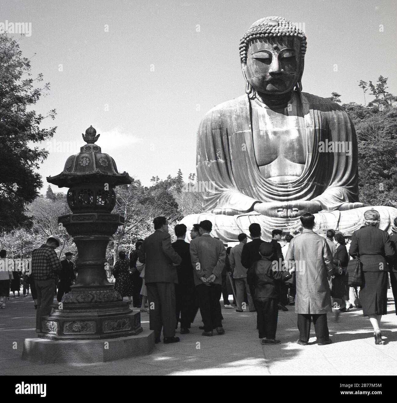 1950-er Jahre, historisch, Besucher der heiligen Bronzestatue, des großen Buddha von Kamakura, Japan, die auf dem Gelände des Kotoku-in-Tempels steht und ein historisches Wahrzeichen des Landes aus dem Jahr 1252. Stockfoto