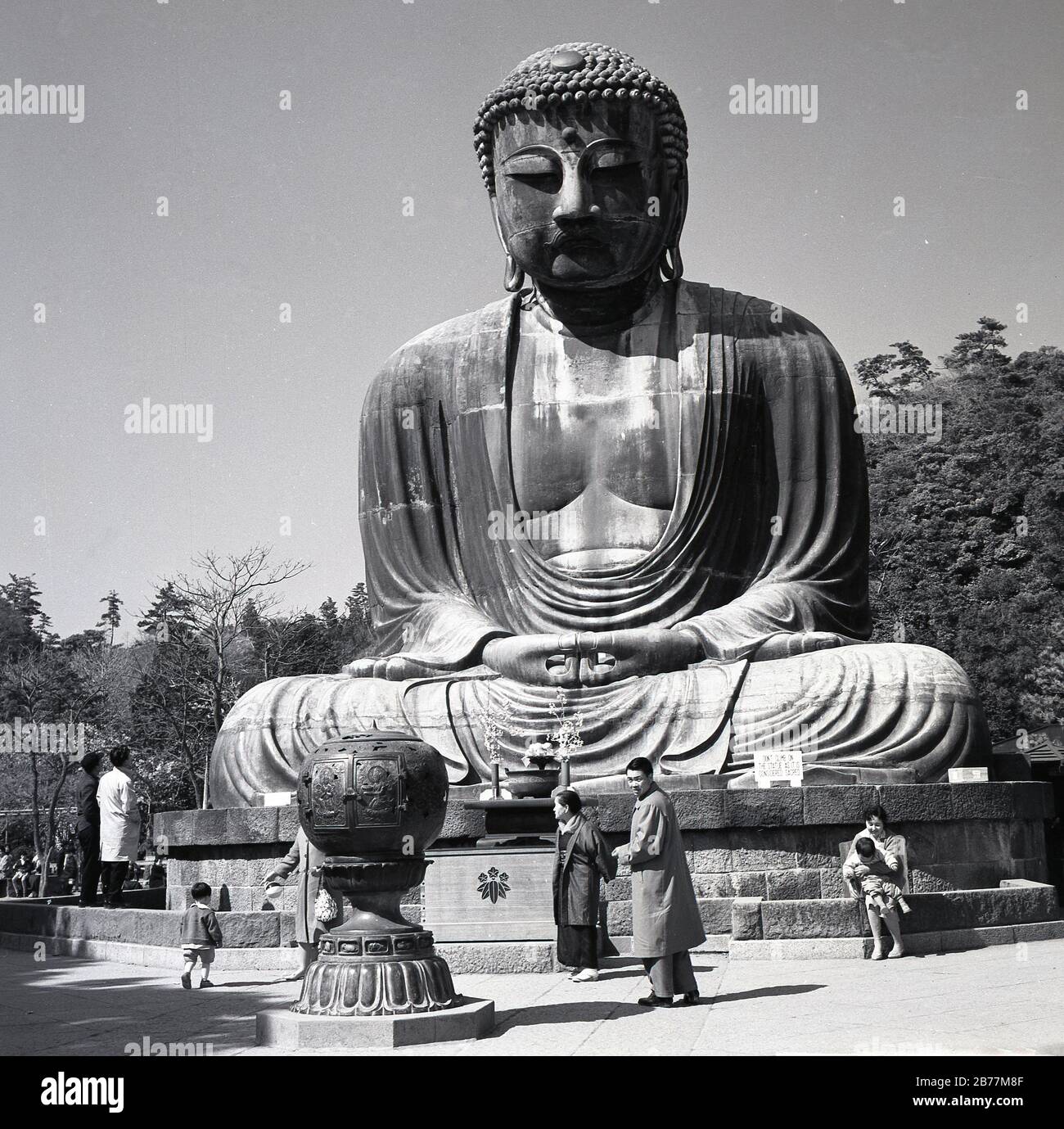1950-er Jahre, historisch, Besucher der heiligen Bronzestatue, des großen Buddha von Kamakura, Japan, die auf dem Gelände des Kotoku-in-Tempels steht und ein historisches Wahrzeichen des Landes aus dem Jahr 1252. Stockfoto