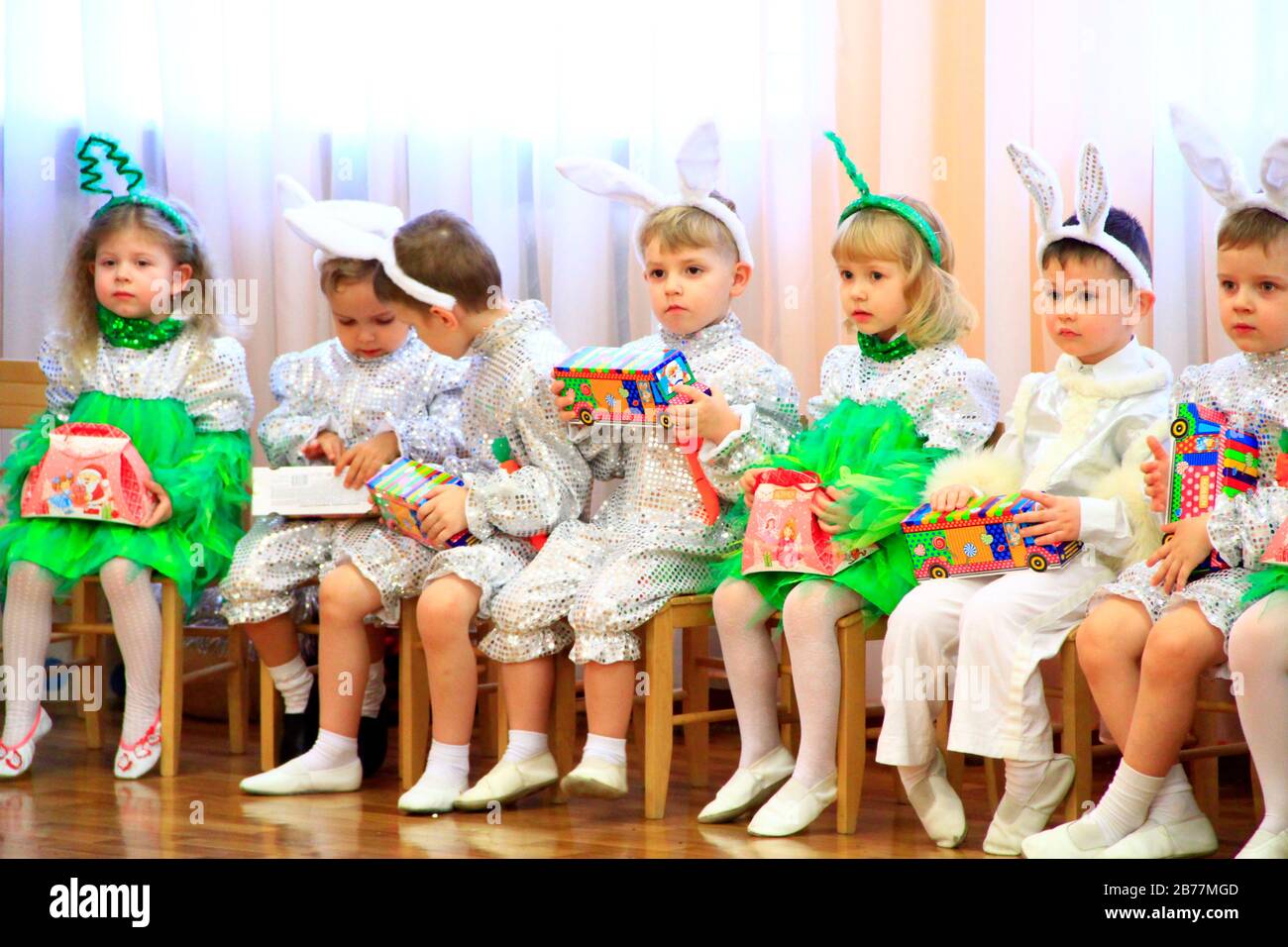 Kinder in Kostümen sitzen Neujahr auf Matinee im Kindergarten. Kinderleistung. Feenschau mit Kindern. Kinder in Ferienanzügen si Stockfoto