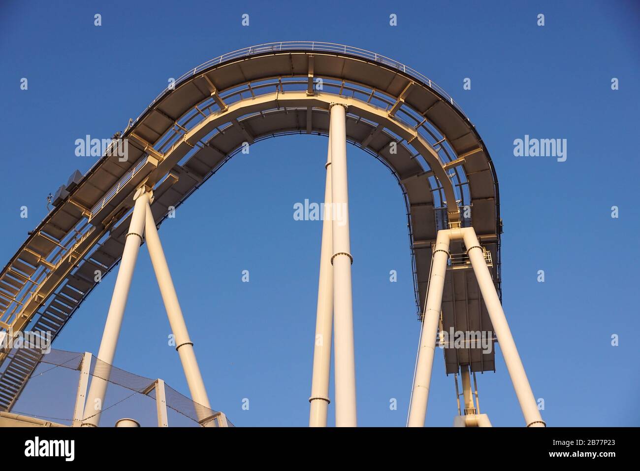 Details der gebogenen Achterbahnstrecke bei Sonnenuntergang Stockfoto