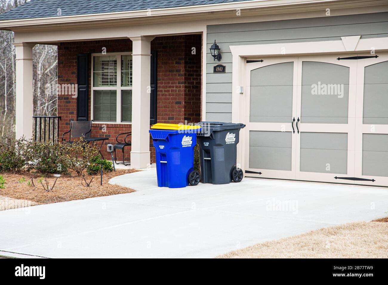 Müll- und Recyclingbehälter vor dem Haus Stockfoto