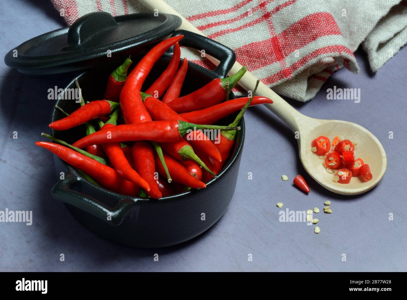 Chilis in kleinem Topf und Kochlöffel, Deutschland Stockfoto