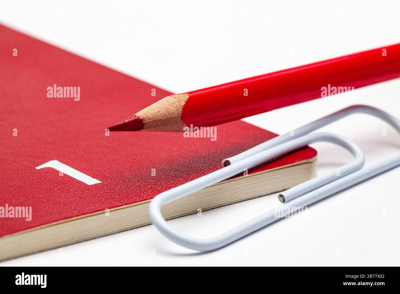 Veranstalter für den Monat Januar, roter Bleistift und weiße Büroklammer auf dem weißen Tisch. Stockfoto