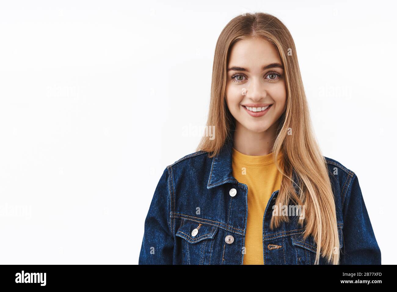 Lifestyle-, Bildungs- und Frauenkonzept. Optimistisches, fröhliches blondes nettes Mädchen in Jeans-Jacke über T-Shirt, aufrichtig lächelnd und zum Ausdruck gebracht Stockfoto