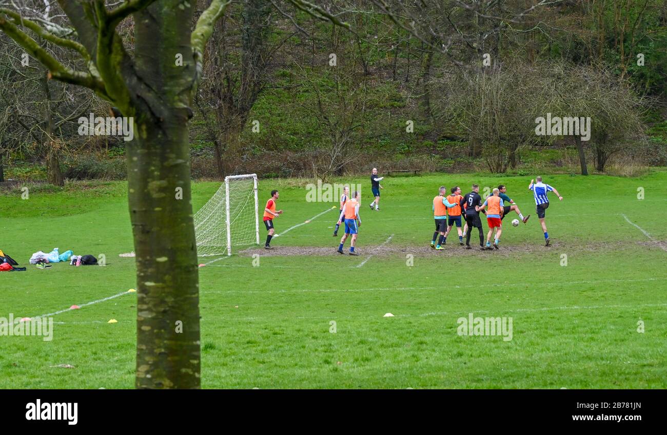 Brighton UK, 14. März 2020 - Die Fußballer genießen ein Spiel des Parksfußballs auf den Patcham Place Pitches am nördlichen Stadtrand, da alle Spiele der Premier League und EFL frühestens im April in England aufgrund der Coronavirus-Pandemie ausgesetzt wurden: Credit Simon Dack / Alamy Live News Stockfoto