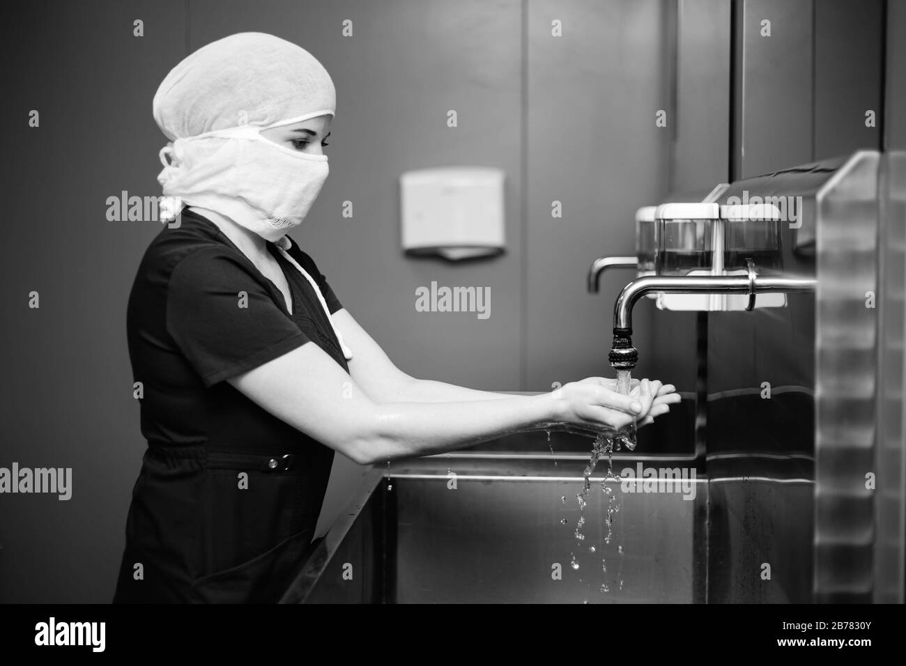 Die Krankenschwester in der medizinischen Schutzmaske wäscht die Hände Stockfoto