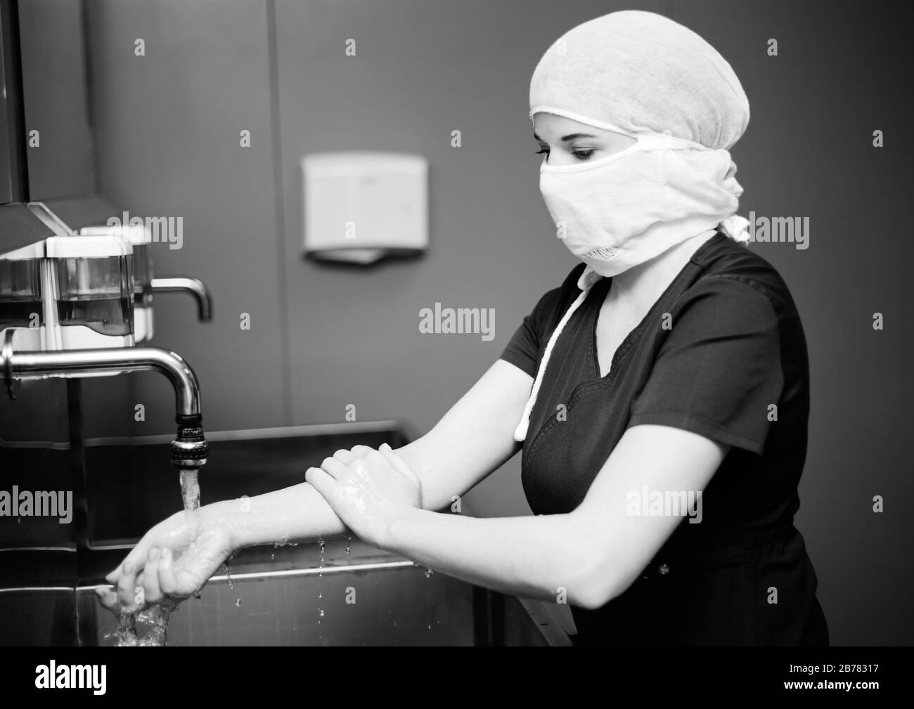 Die Krankenschwester in der medizinischen Schutzmaske wäscht die Hände Stockfoto