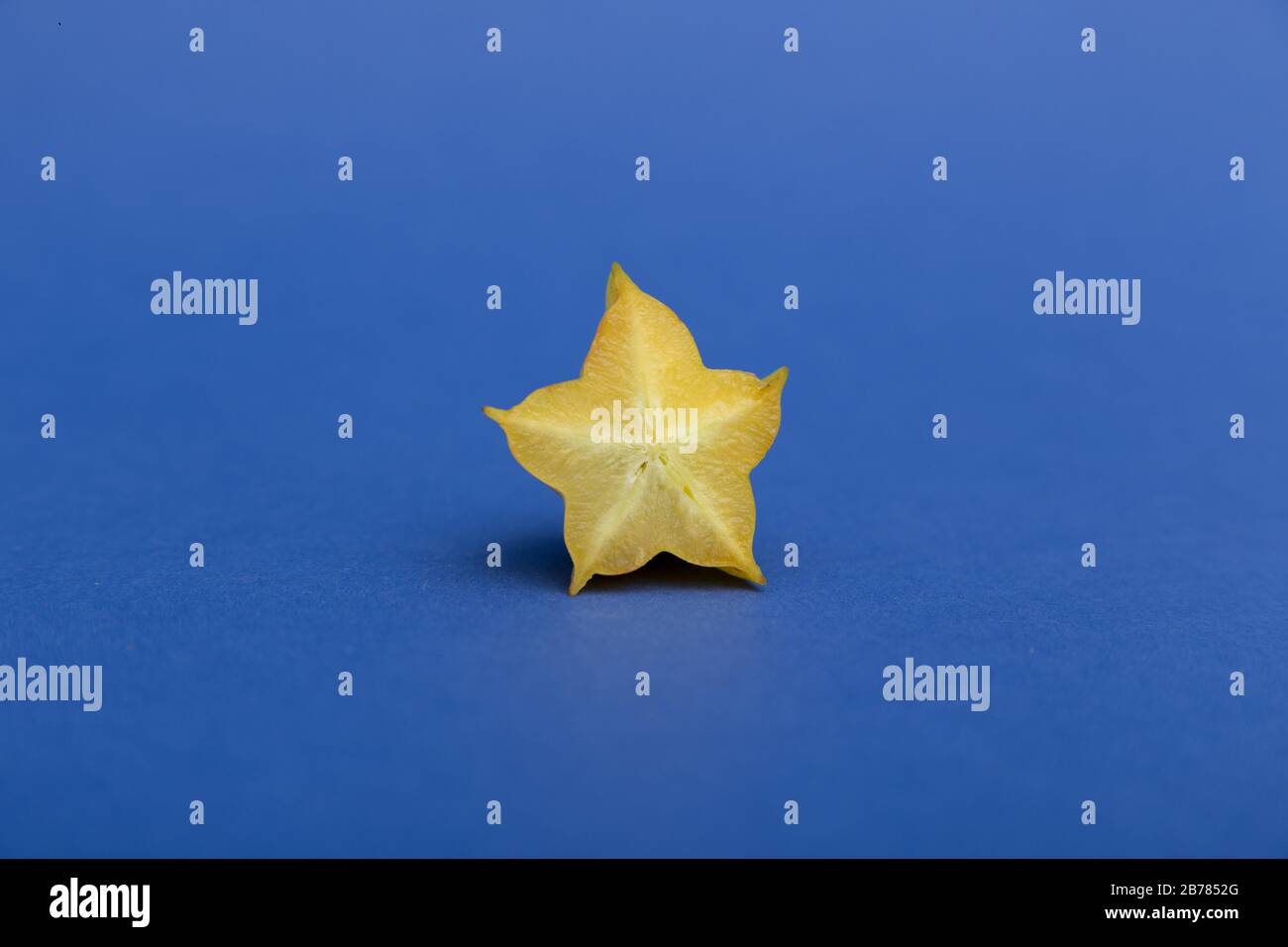 Sternfrucht-Karambola oder starfrucht mit Scheibe auf klassischem blauem Hintergrund. Gesunde Fruchtnahrung. Stockfoto