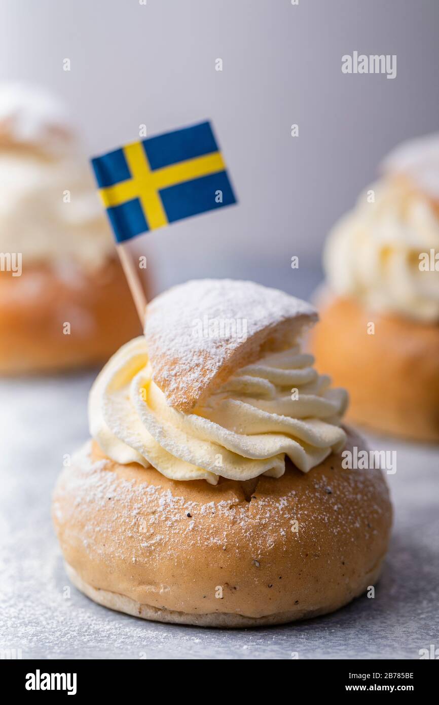 Semla, fastelavnsbolle, fastlagsbulle. Ein traditionelles skandinavisches Kardamom-Bun mit Mandelpaste. Mit schwedischer Flagge dekoriert. Auf einem w Stockfoto