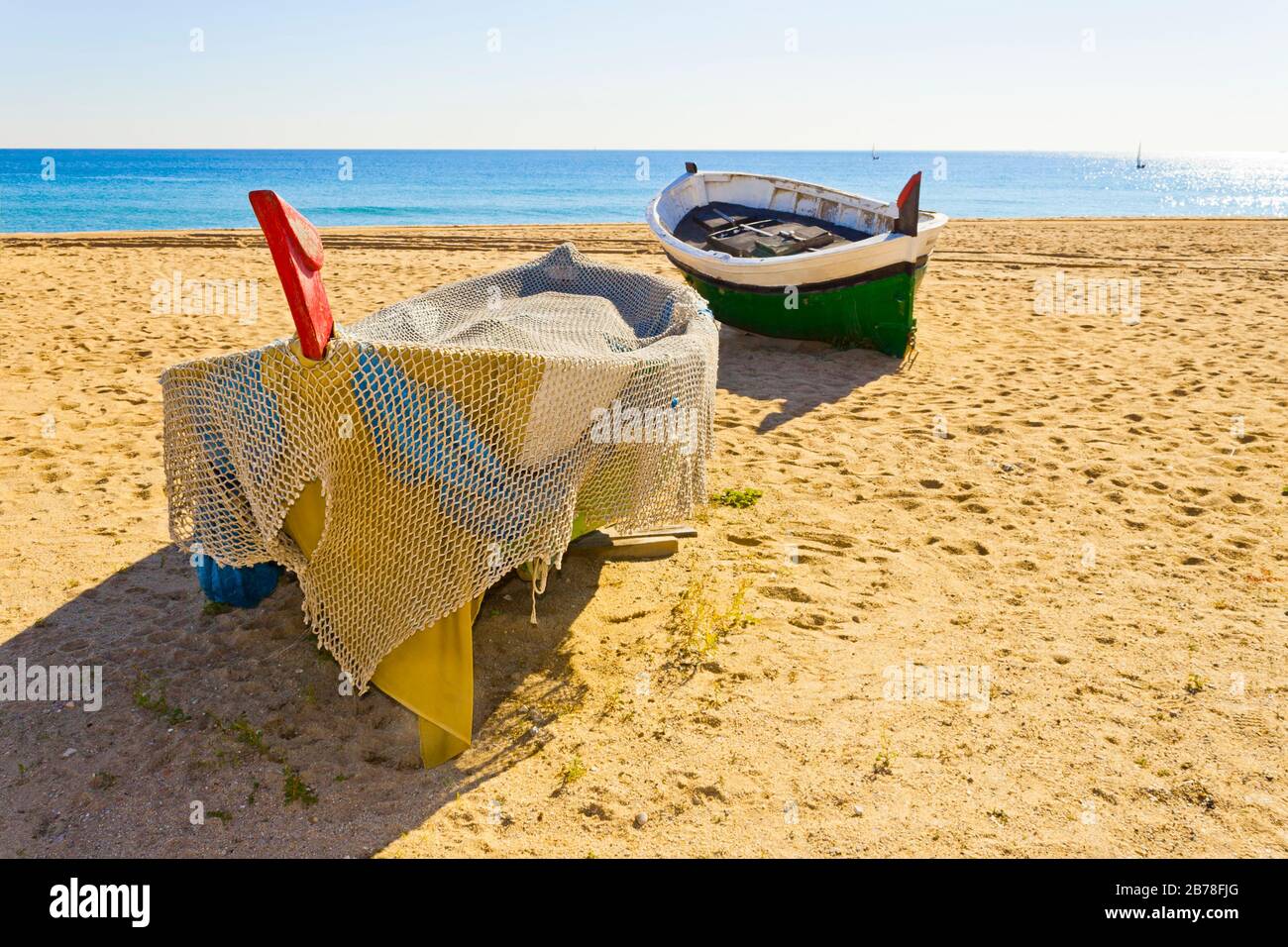 Bunte alte Fischerboote auf dem Strand von Badalona im Mittelmeer an einem sonnigen Tag. Barcelona, Catalunya, Spanien. Stockfoto