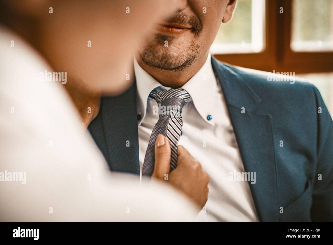 Frau richtet die Krawatte eines Mannes im Büro aus Stockfoto