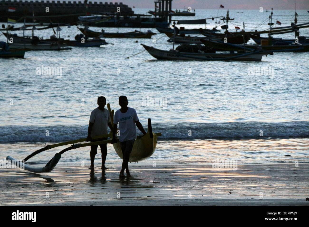 Lokale Männer am Kedonganan Beach im Morgengrauen Stockfoto