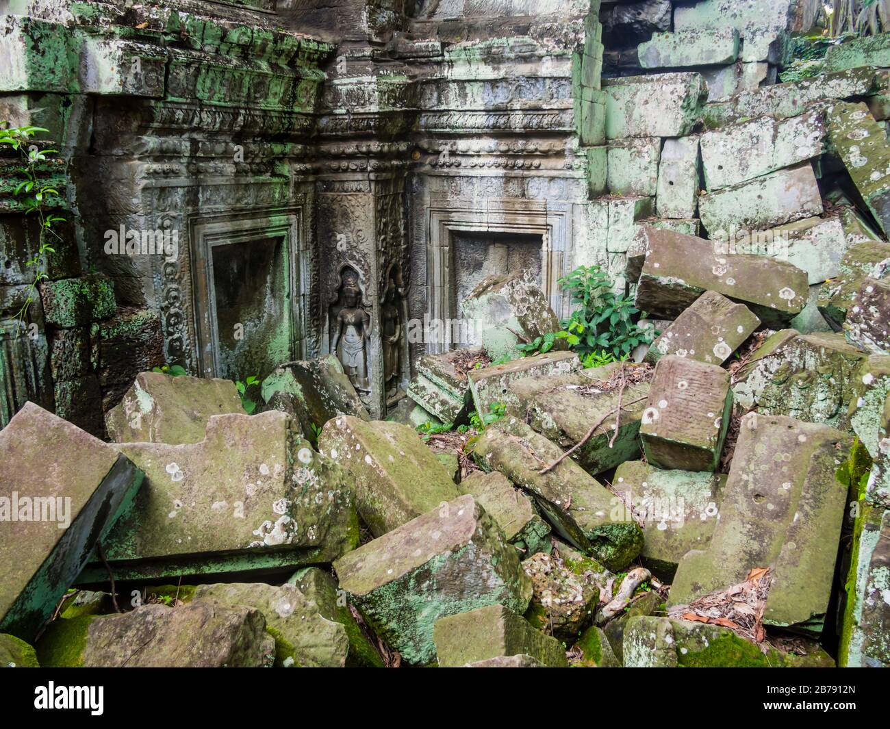 Alte Ruinen des Ta Prohm Tempels mit eingestürzter Steinstruktur und feiner hinduistischer Skulptur im Hintergrund, Angkor, Provinz Siem Reap, Kambodscha Stockfoto