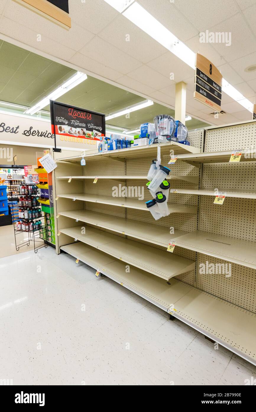 Fast leere Regale in einem Supermarkt Lebensmittelgeschäft in der abgefüllten Wasser-Gang als Coronavirus verursacht Angst und Panik vertikal Stockfoto
