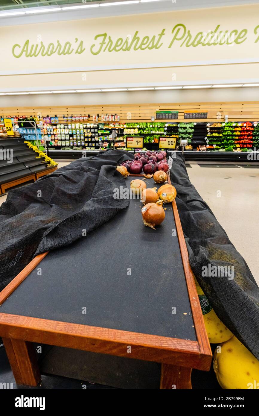 Leere Regale mit Zwiebeln und anderen Produkten in einem Supermarkt Lebensmittelgeschäft als Coronavirus verursacht Angst und Panik Stockfoto