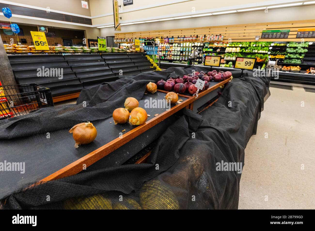 Leere Regale mit Zwiebeln und anderen Produkten in einem Supermarkt Lebensmittelgeschäft als Coronavirus verursacht Angst und Panik Stockfoto