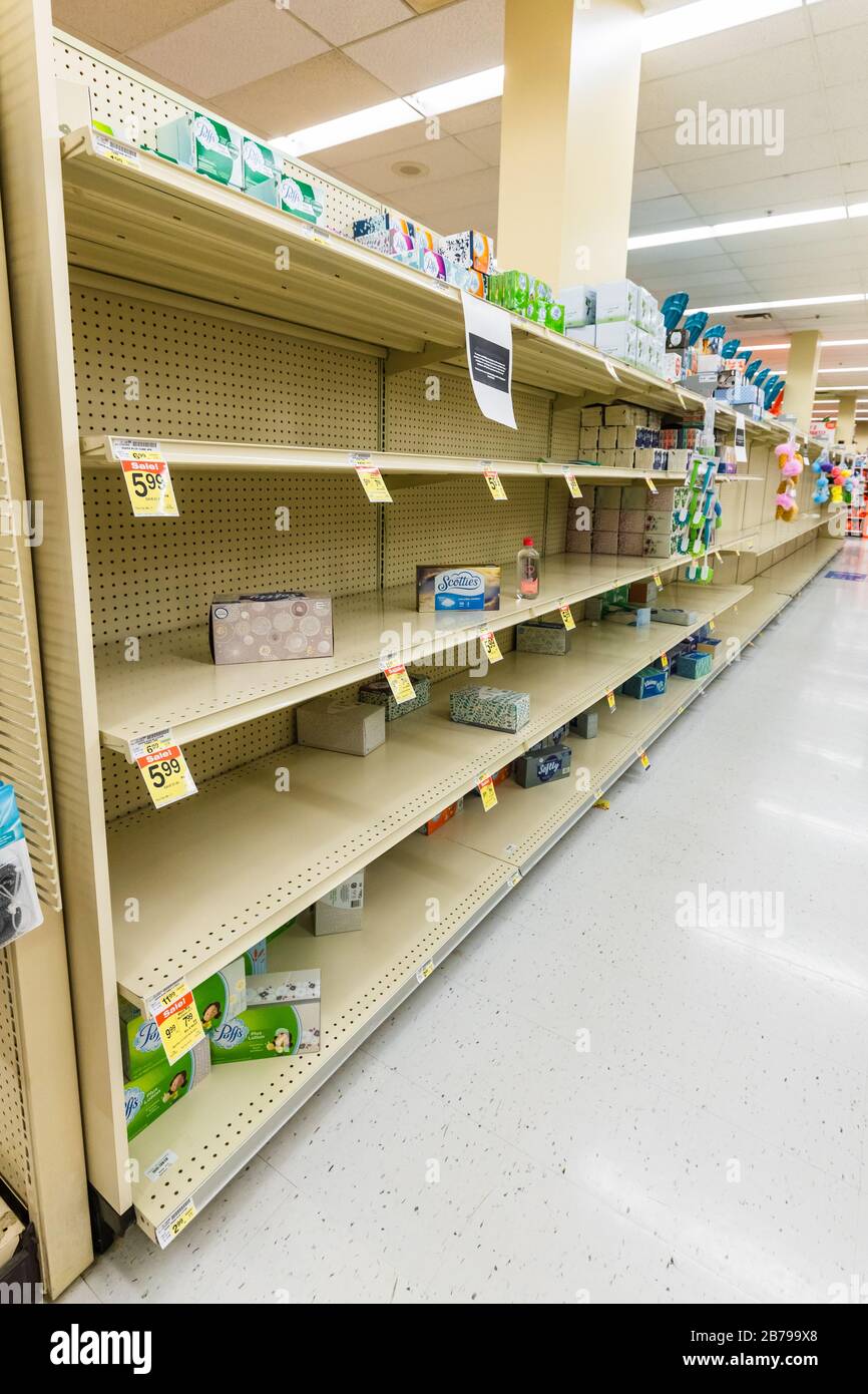 Fast leere Regale in einem Supermarkt Lebensmittelgeschäft in der Gewebekiste Gang als Coronavirus verursacht Angst und Panik Stockfoto