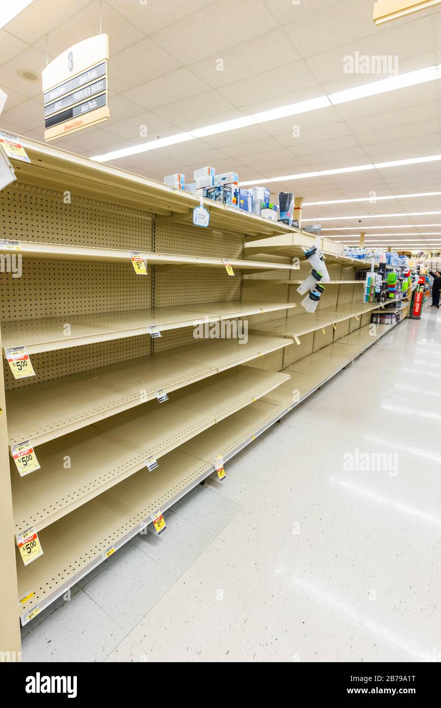 Leere Regale in einem Supermarkt Lebensmittelgeschäft in der Wasserinsel in Flaschen, da Coronavirus Angst und Panik horizontal verursacht Stockfoto