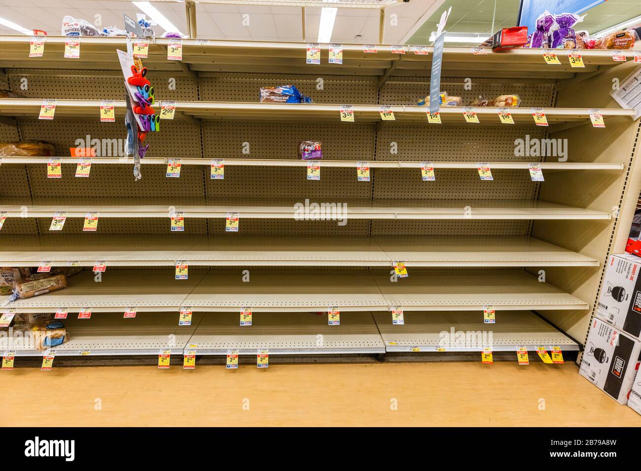 Fast leere Regale in einem Supermarkt Lebensmittelgeschäft in der Brotinsel als Coronavirus verursacht Angst und Panik horizontal Stockfoto