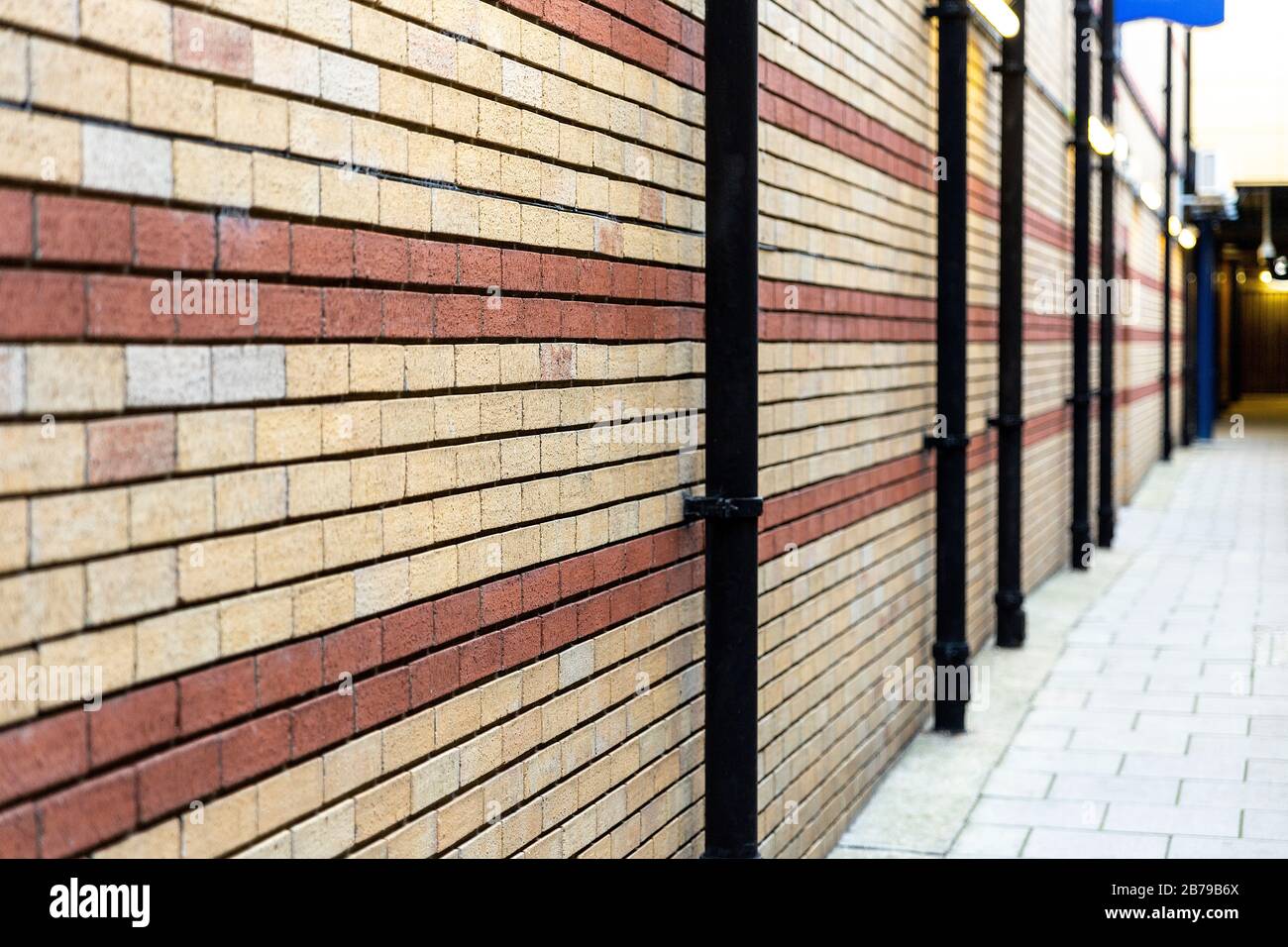 Rot und beige bemalte Backstein-Wand-Hintergrundtextur Nahaufnahme. Detaillierte Ansicht. Selektiver Fokus. Stockfoto