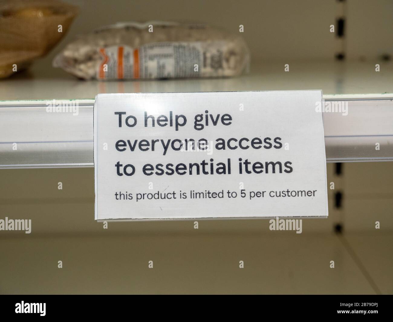 Ein Zeichen, das den Verkauf von Artikeln in leeren Regalen im Tesco Supermarkt in Cambridgeshire UK einschränkt, während Menschen als Reaktion auf das Coronavirus in Panik Lebensmittel kaufen. Stockfoto