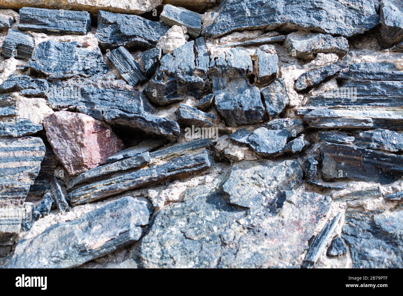Steinmauern. Schöner und interessanter Hintergrund. Grober Aufbau. Mossy Stein. Alte Wand. Braun und Schwarz. Stockfoto