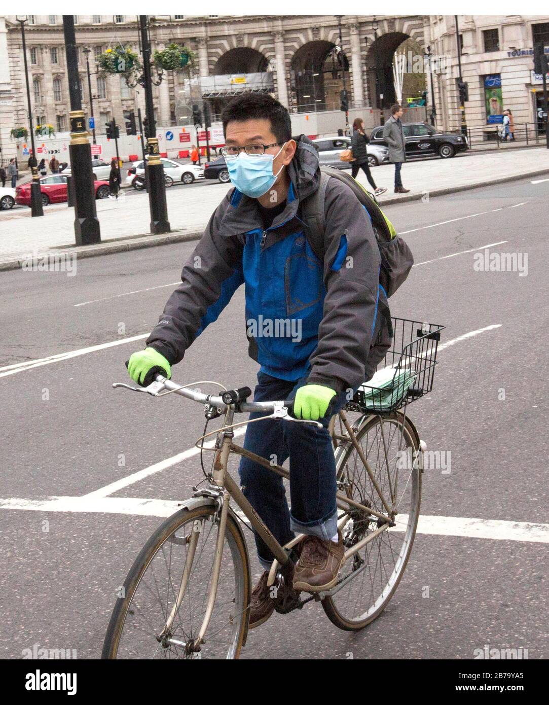 Ein Mann in einer Maske, der in London radelt, nachdem der Premierminister sagte, dass Covid-19 "die schlimmste öffentliche Gesundheitskrise für eine Generation ist", und der Top-Wissenschaftler der Regierung warnte, dass bis zu 10.000 Menschen in Großbritannien bereits infiziert sind. PA Foto. Bilddatum: Samstag, 14. März 2020. Siehe PA Story HEALTH Coronavirus. Der Fotowand sollte lauten: Rick Findler/PA Wire Stockfoto