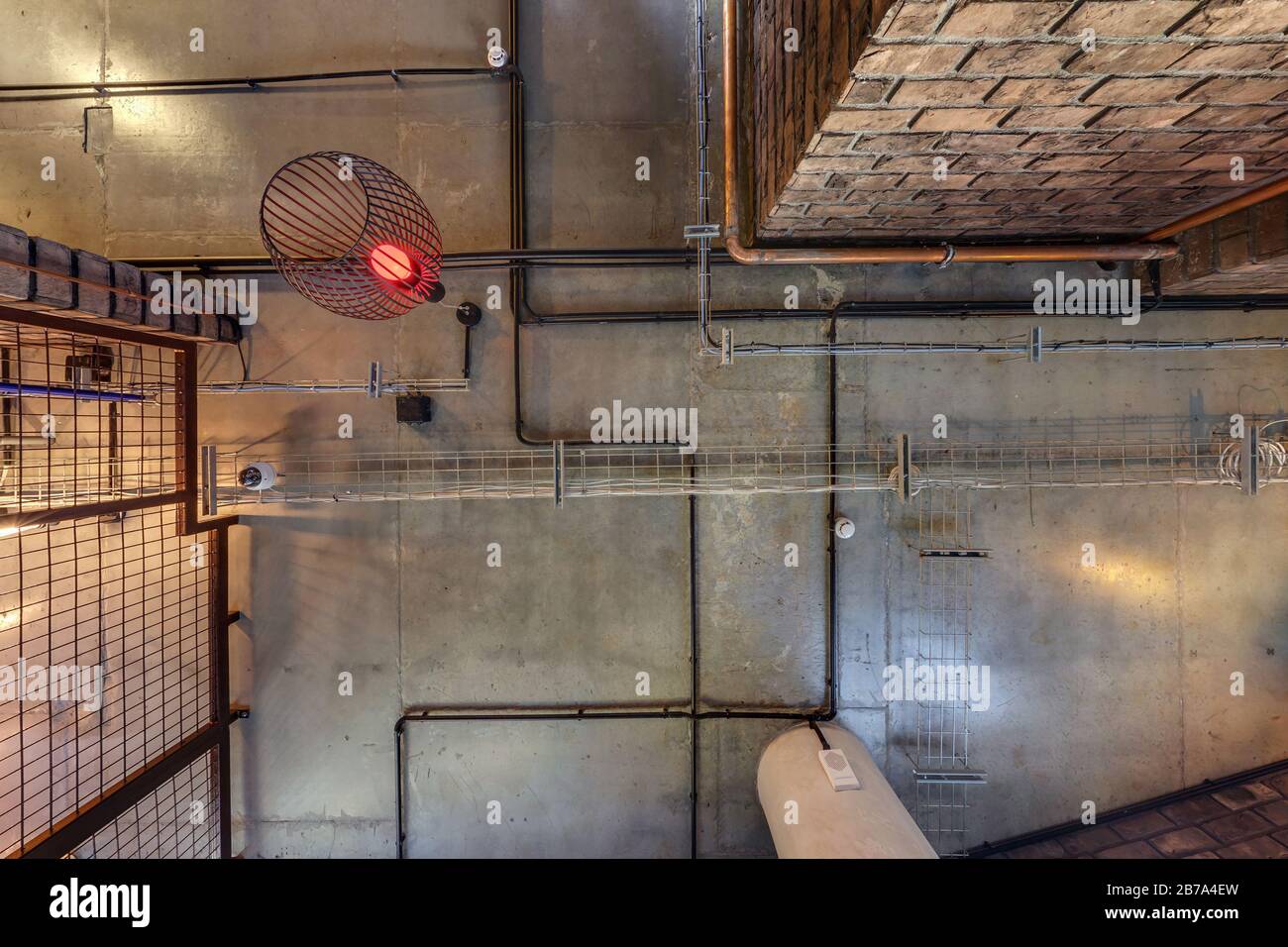 Graue Betondecke mit Halogenflecken und edison-lampen im Loft-Büroraum mit  Klimaanlage und orangefarbenem Belüftungsrohr. Blick nach oben, graue  Klimaanlage Stockfotografie - Alamy