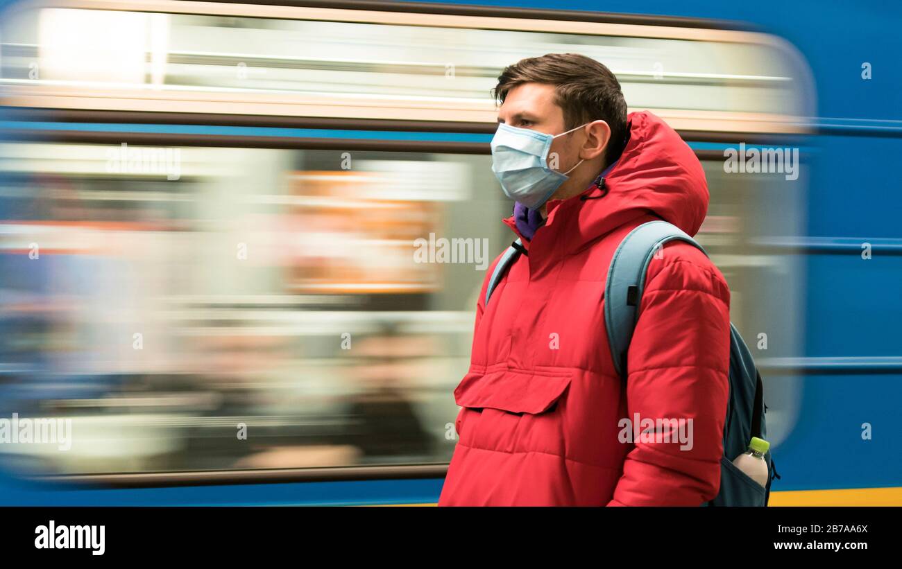 Der junge europäer ist in der U-Bahn in einer schützenden, medizinischen Gesichtsmaske. Neues Coronavirus (COVID-19). Konzept der Gesundheitsversorgung während eines Epigemi Stockfoto