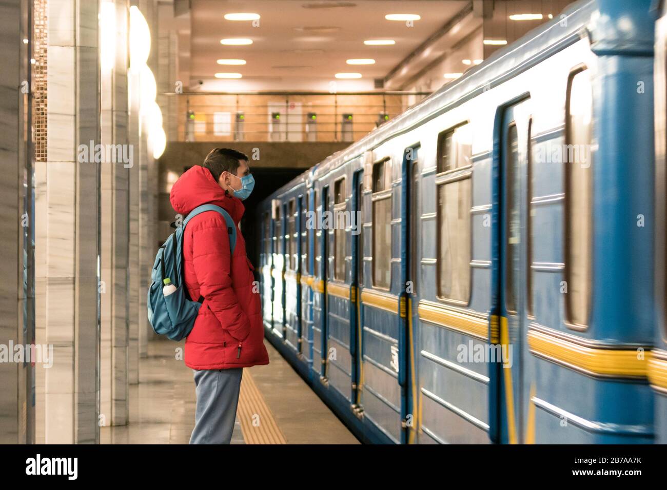 Der junge europäer ist in der U-Bahn in einer schützenden, medizinischen Gesichtsmaske. Neues Coronavirus (COVID-19). Konzept der Gesundheitsversorgung während eines Epigemi Stockfoto