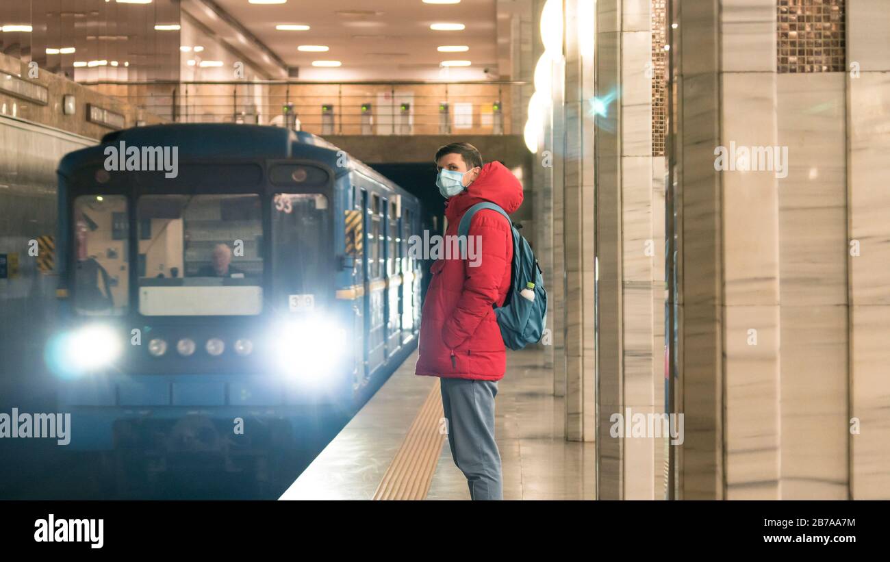 Der junge europäer ist in der U-Bahn in einer schützenden, medizinischen Gesichtsmaske. Neues Coronavirus (COVID-19). Konzept der Gesundheitsversorgung während eines Epigemi Stockfoto