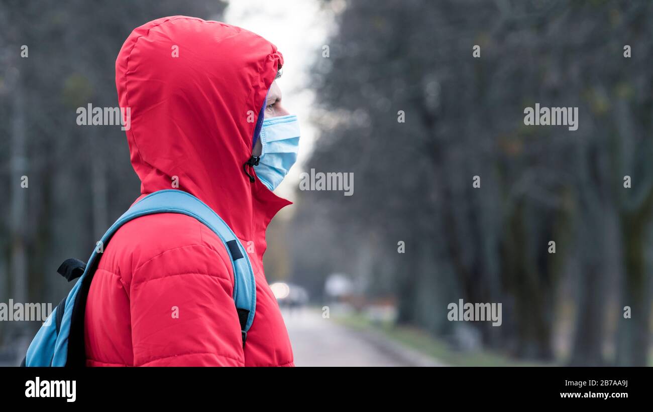 Nahaufnahme Portrait junger europäer Mann in schützender, medizinischer Gesichtsmaske, die draußen spazieren geht. Neues Coronavirus (COVID-19). Konzept der Gesundheitsversorgung Stockfoto