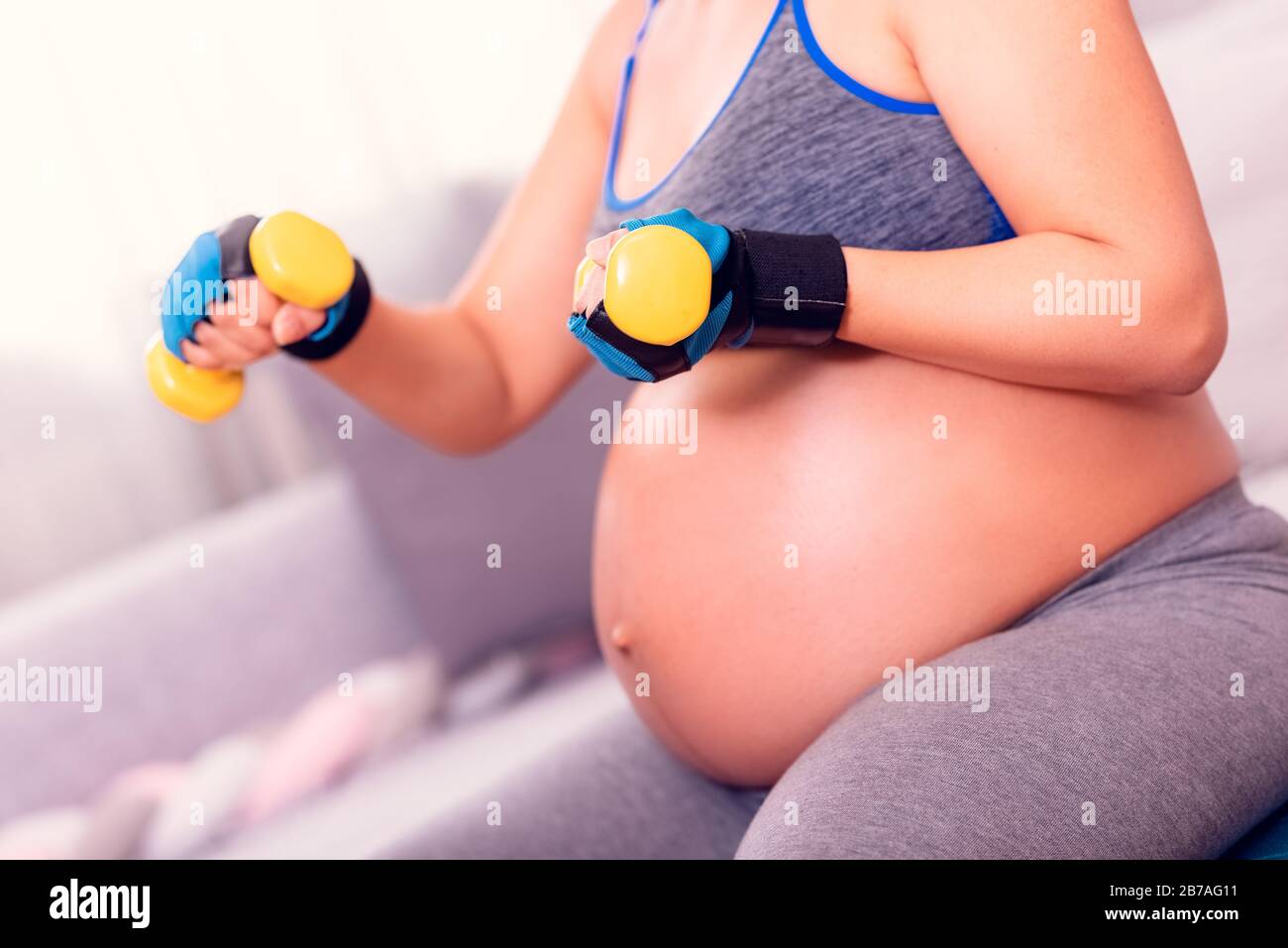 Schwangeres Frauentraining. Während der Schwangerschaft aktiv bleiben und mit Hanteln trainieren. Stockfoto