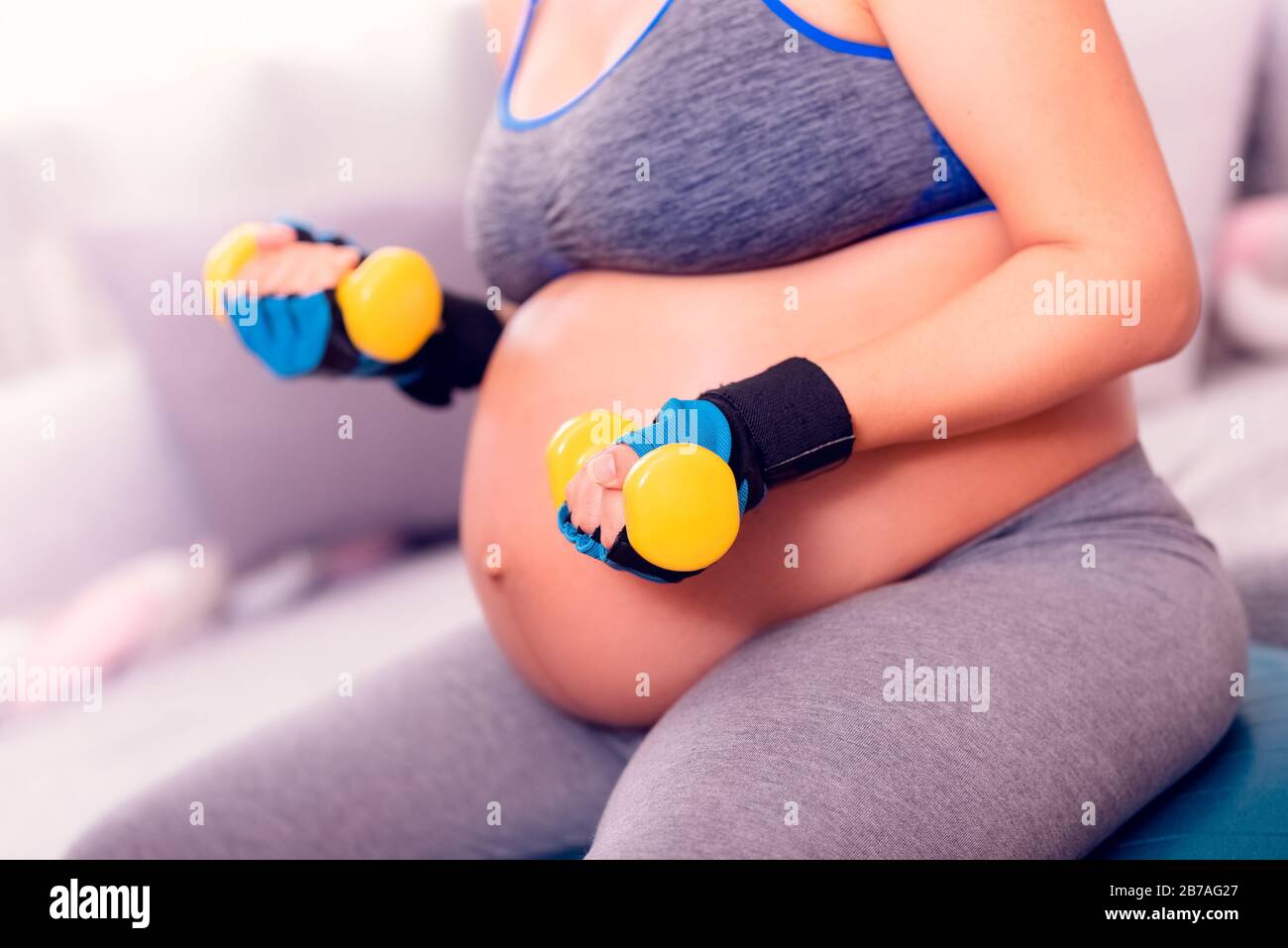 Schwangeres Frauentraining. Während der Schwangerschaft aktiv bleiben und mit Hanteln trainieren. Stockfoto