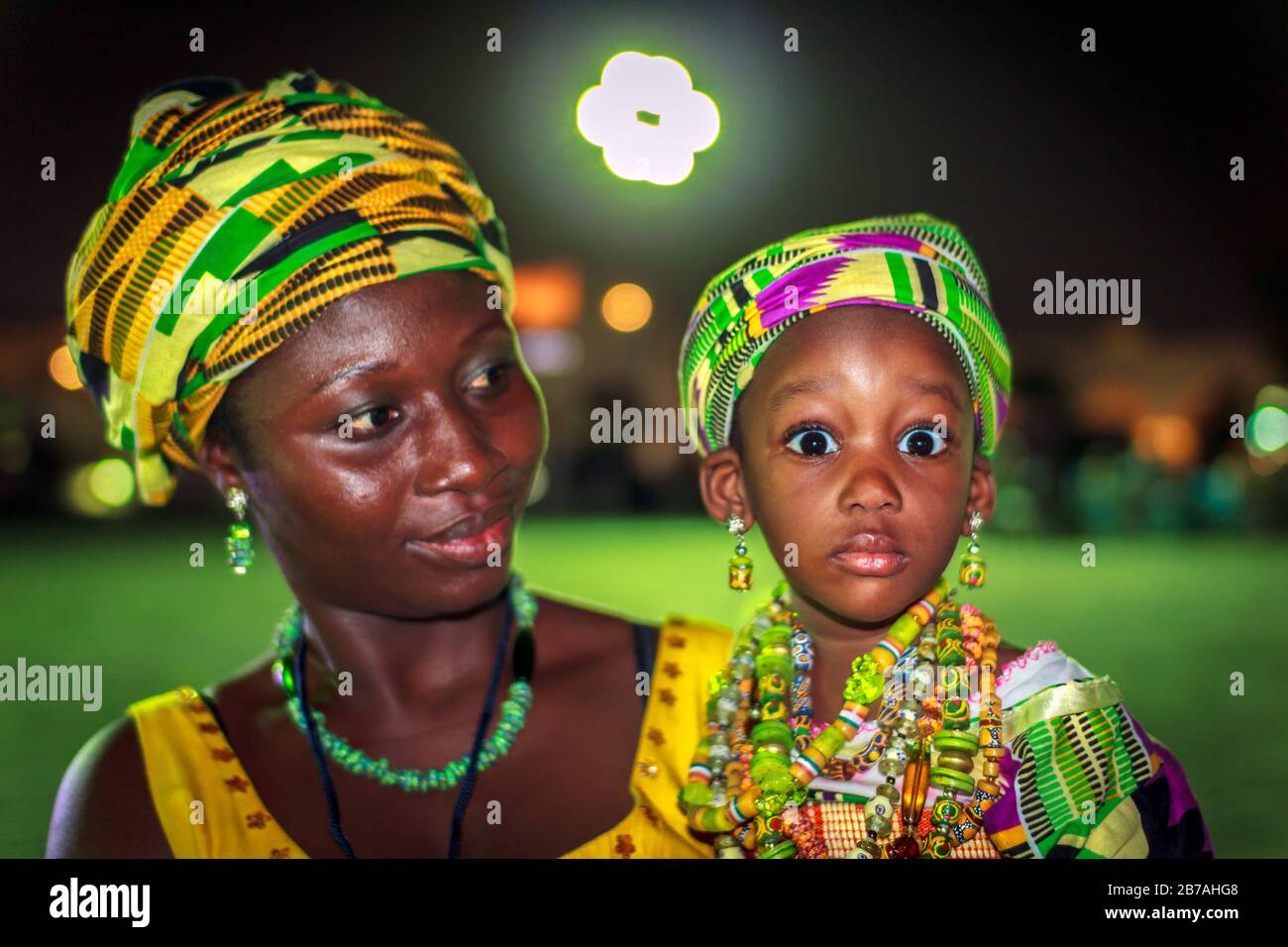 Afrikanisches Mutter- und Tochterporträt in traditionellen Stammkostümen mit verschwommenem Hintergrund Stockfoto