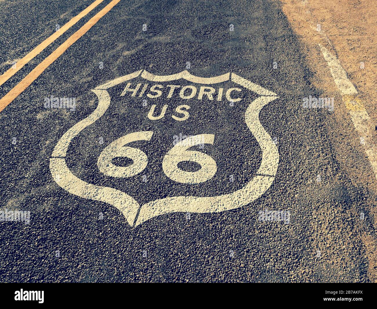 Historisches Schild der US Route Road 66, bedeckt mit Wüstensand Stockfoto